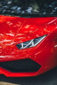 Close-up of a red Lamborghini Huracan parked on a street in New Delhi, India.